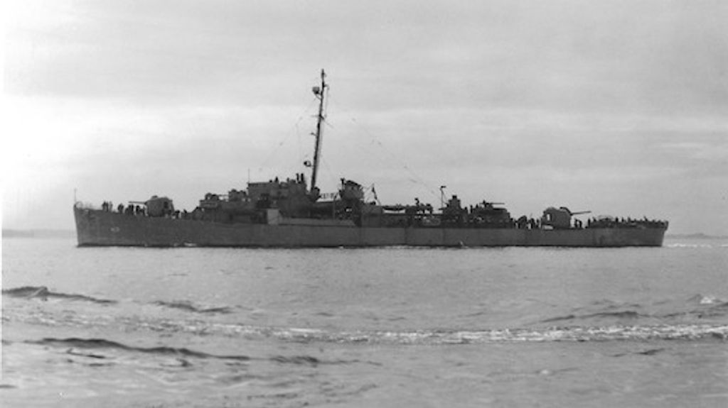 a black and white photo of the WWII ship on the water before it sunk and became the world's deepest shipwreck