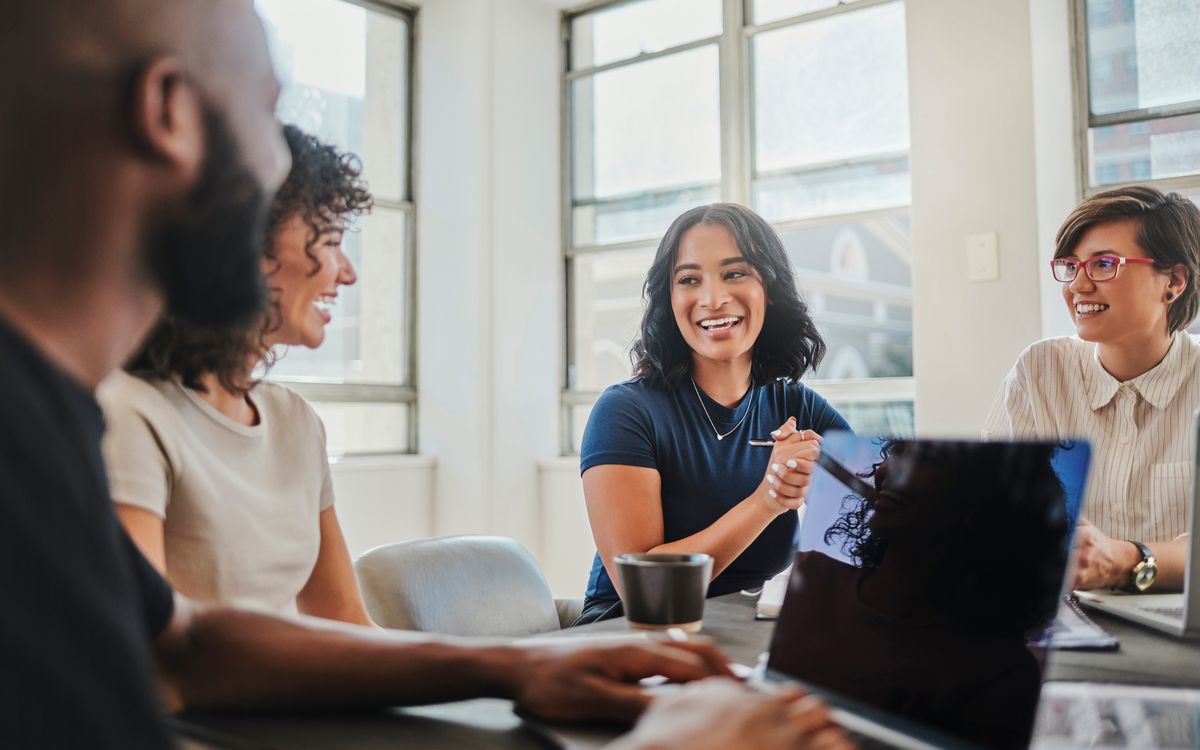 Business meeting, global company and teamwork diversity with laptop, black man and women in South African office. Smile, happy or creative people in communication, collaboration and strategy planning Delmaine Donson/ iStock